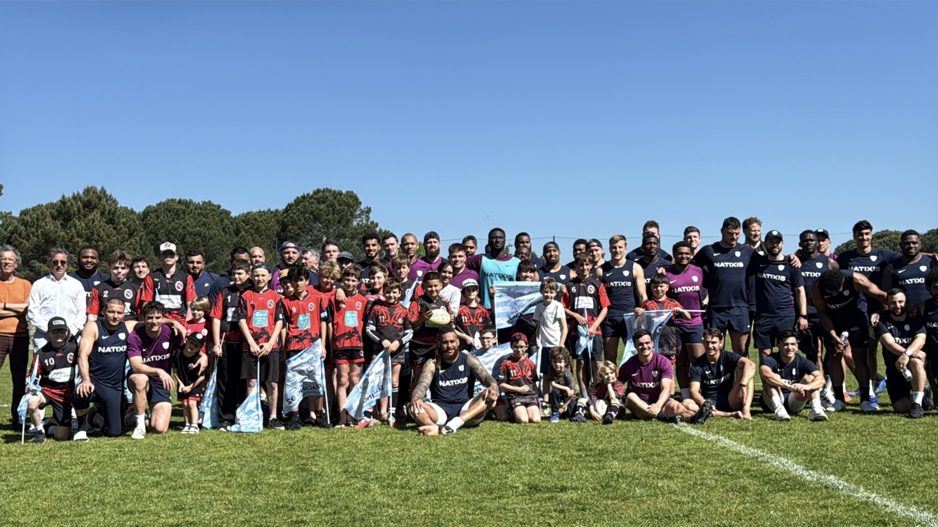 Photo de groupe de sportofs sur un terrain, grand ciel bleu