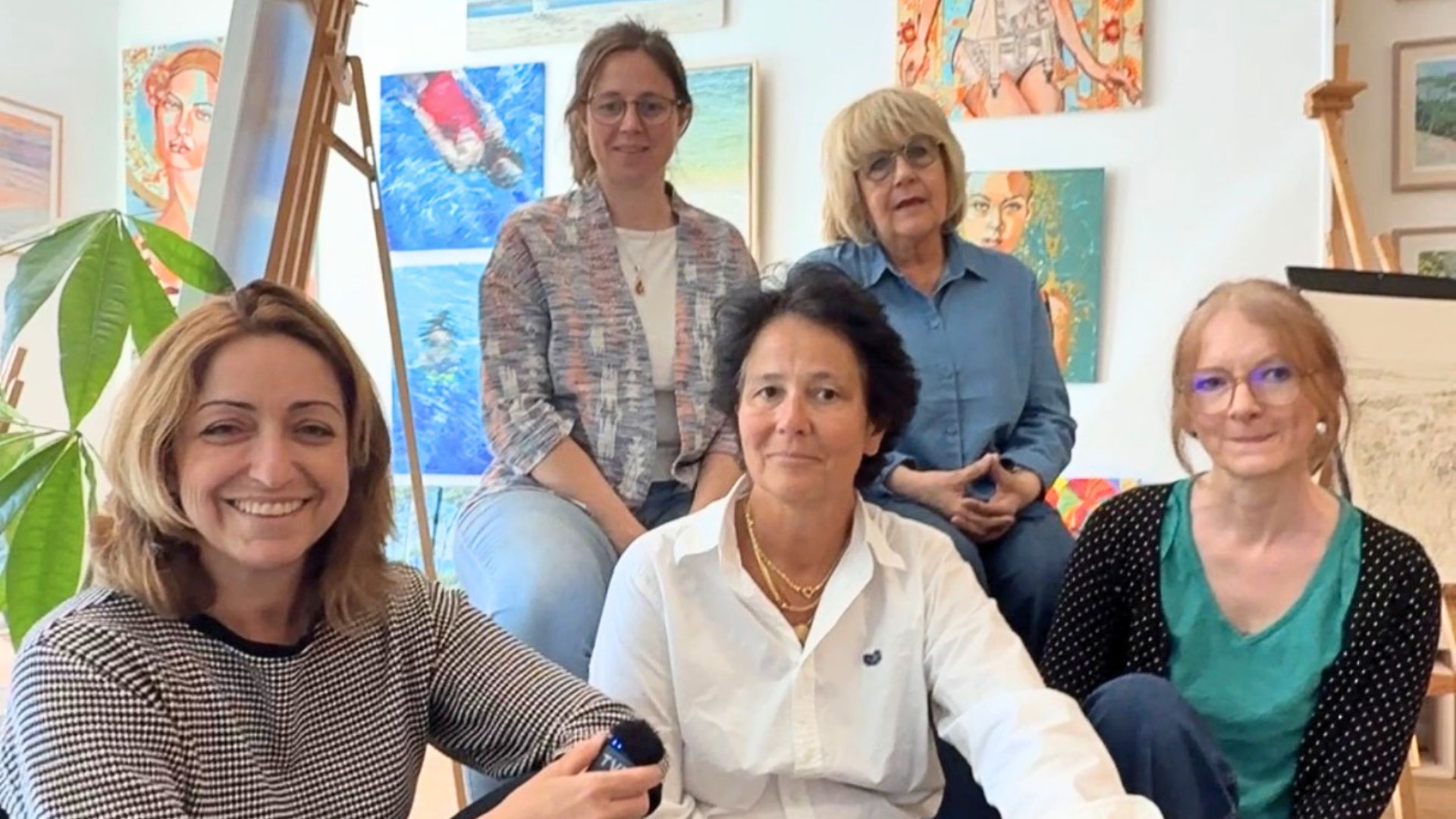 Un groupe de femme dans une pièce lumineuse remplie de tableaux
