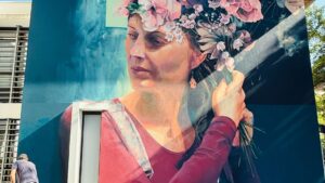 Une fresque sur un mur représentant une femme coifée de fleurs