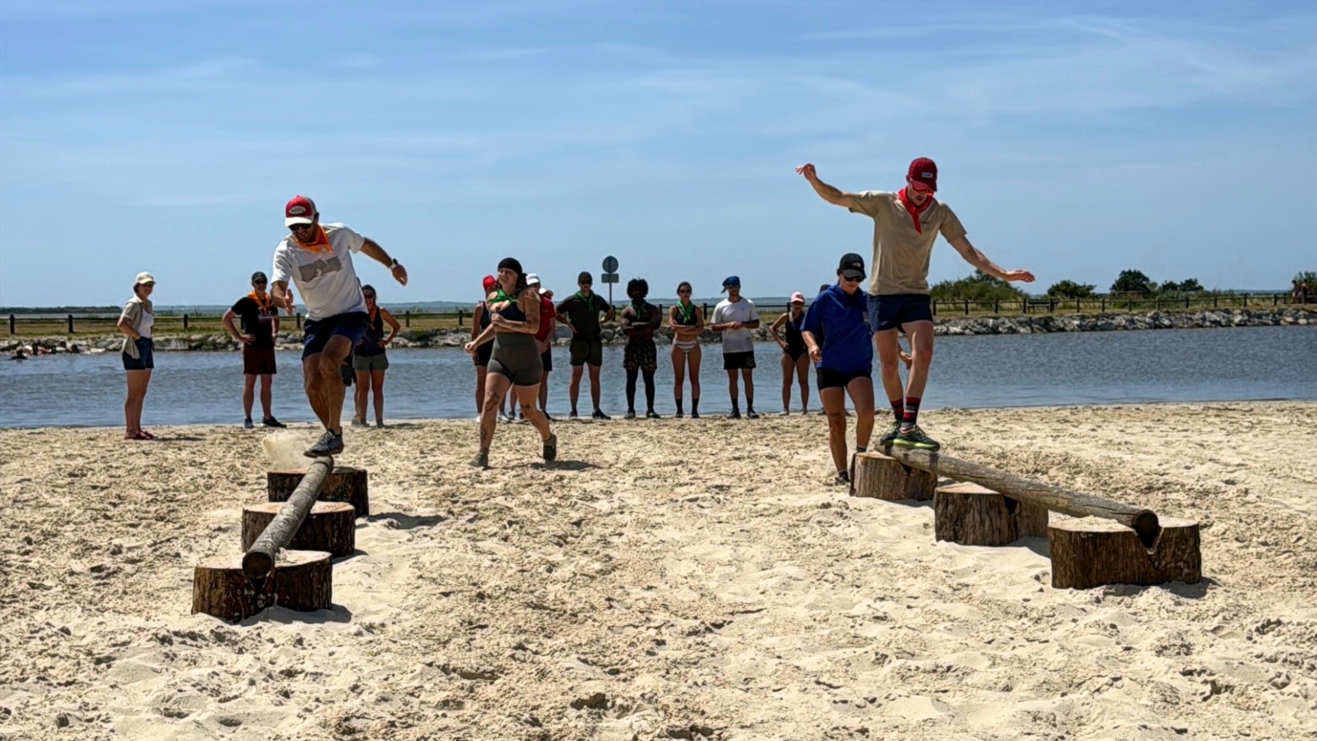 deux personnes sur des poutres en équilibres avec des personnes en arrière plan sur la plage de Lanton pour Koh Lanton