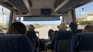 intérieur d'un car régional avec des personnes assises et la plage en arrière plan
