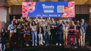 des personnes sur une scène avec des prix dans les mains et un écran en arrière plan faisant mention des lauréats des talents des territoires 2026