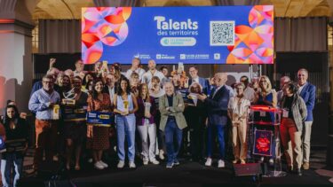 des personnes sur une scène avec des prix dans les mains et un écran en arrière plan faisant mention des lauréats des talents des territoires 2026
