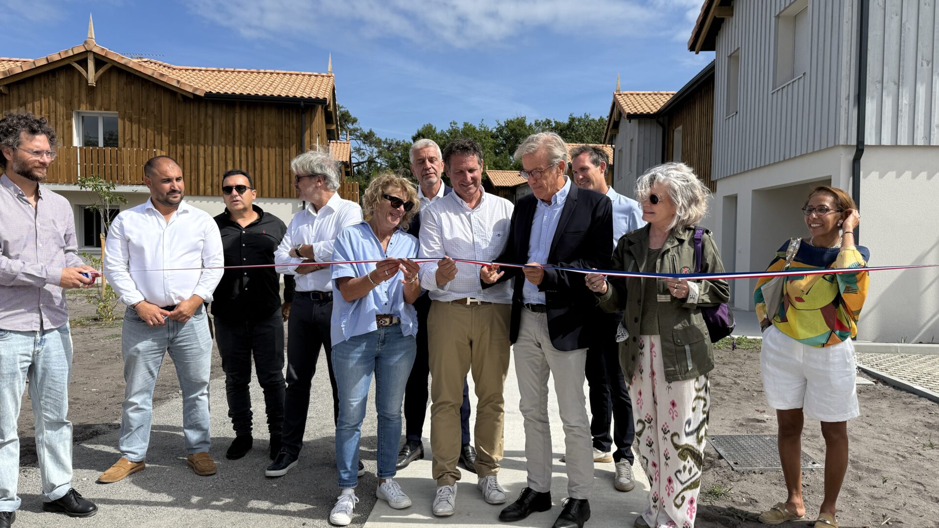 Plusieurs personnes dont le maire de Lège-Cap Ferret, Phillippe de Gonneville inaugure la nouvelle résidence en coupant le ruban.