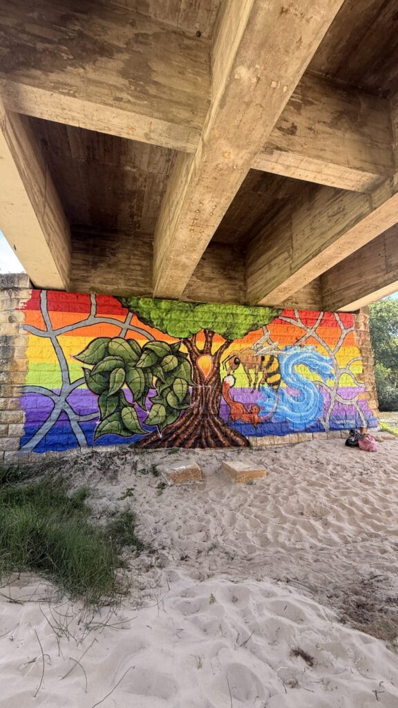 Sous le pont de l'Eyre, à Mios, une fresque horizontale de plusieurs mètres fait figurer un autre au centre et un arc-en-ciel en arrière-plan.