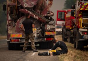 pompier allongé devant le camion, dans un air enfumé