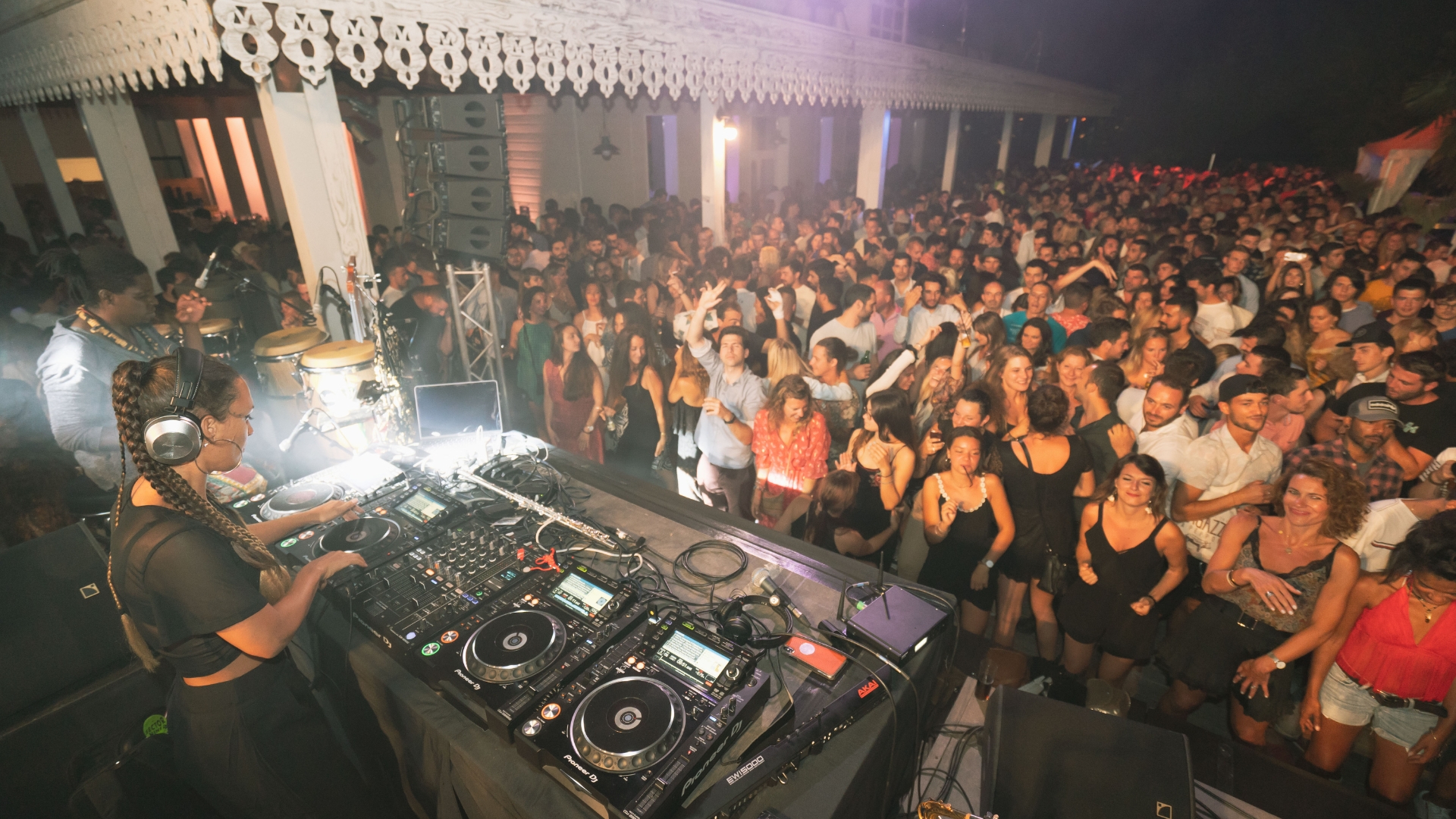 foule de personnes devant une scène avec un dj en train de miwer pour las oirée magik oasis de gujan