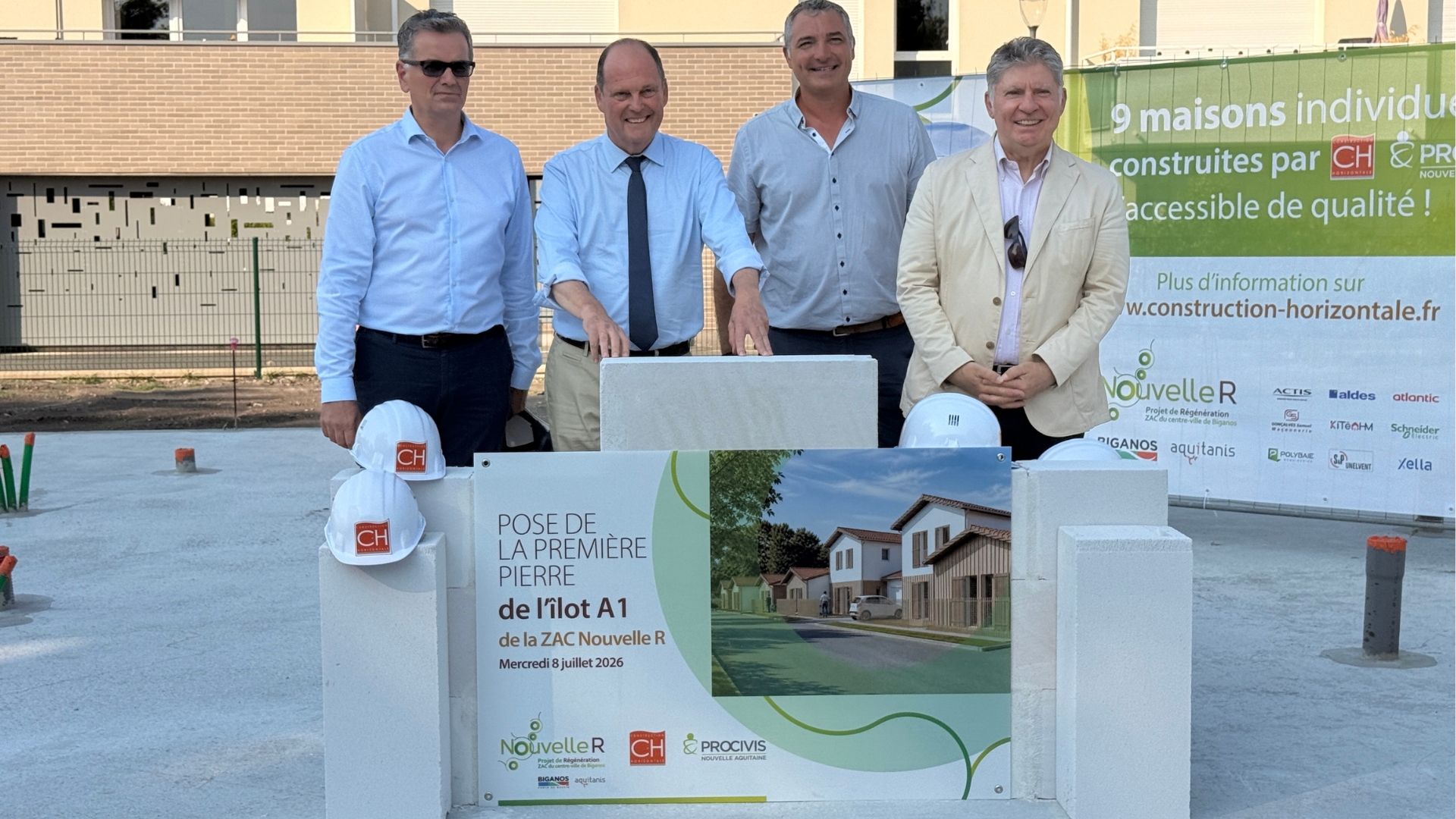 4 hommes devant un petit muret symbolisant la pose de la premiere pierre des maisons individuelles de la ZAC de biganos