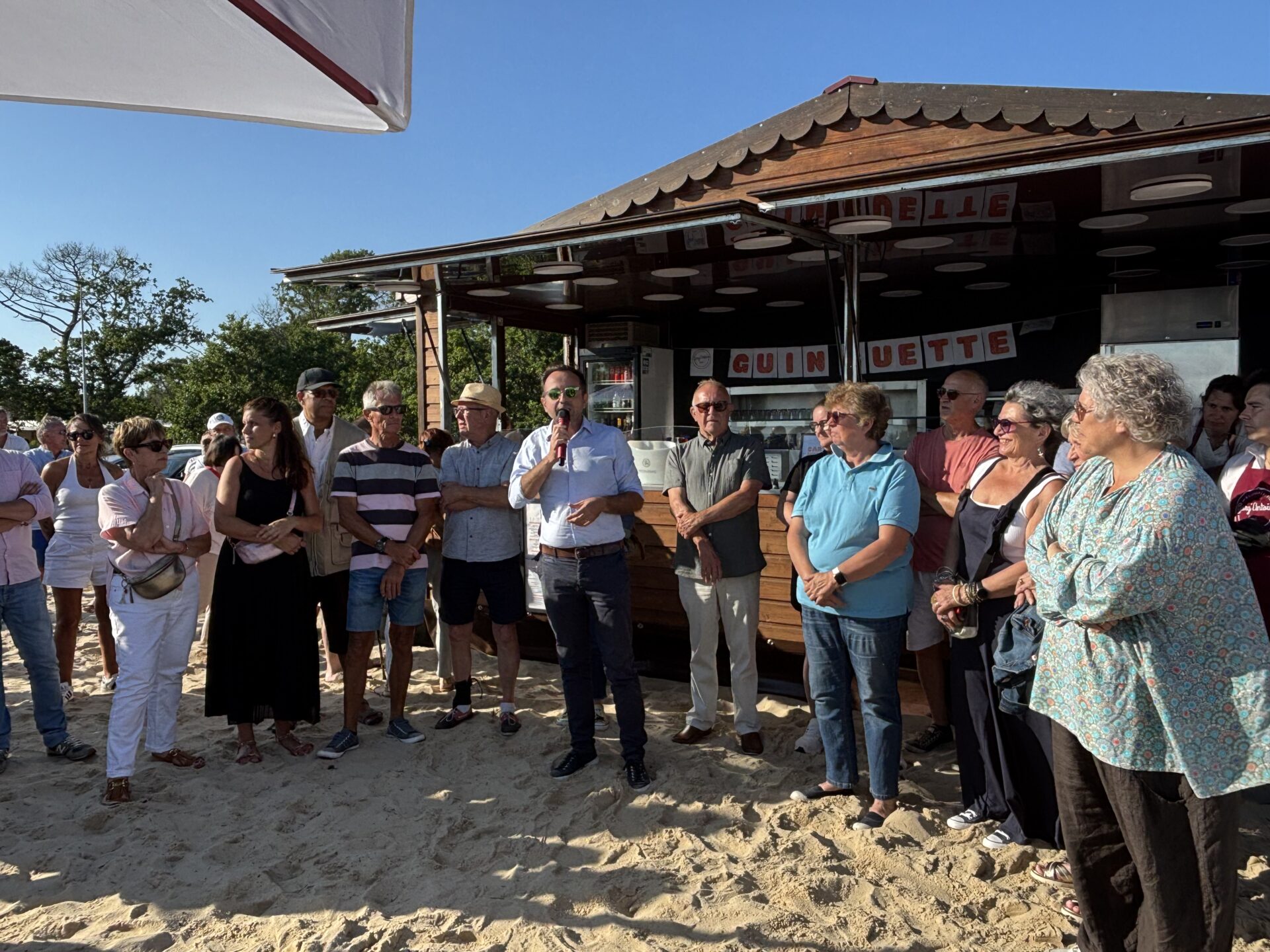 Le maire de Lanton, Loïc Ballongue est accompagné de plusieurs personnes pour inaugurer la guinguette situé derrière lui.