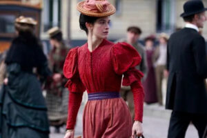 Une femme en robe rouge dans la rue, reconstitution d'autrefois