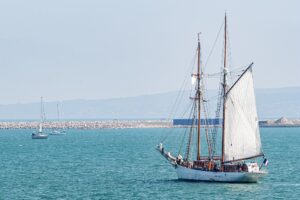 une goelette avec une voile déployée navique au large des côtes