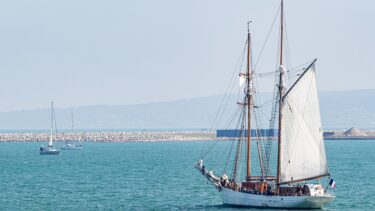 une goelette avec une voile déployée navique au large des côtes