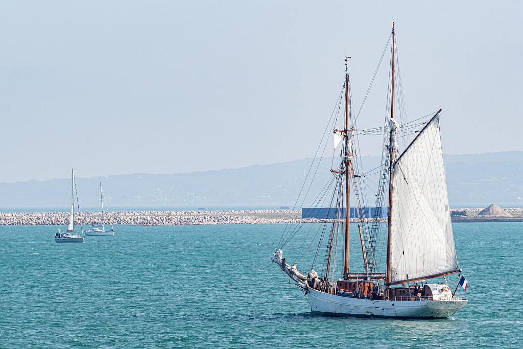 une goelette avec une voile déployée navique au large des côtes