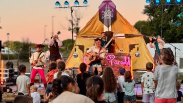 une troupe de cirque devant le public, coucher de soleil dans le fond