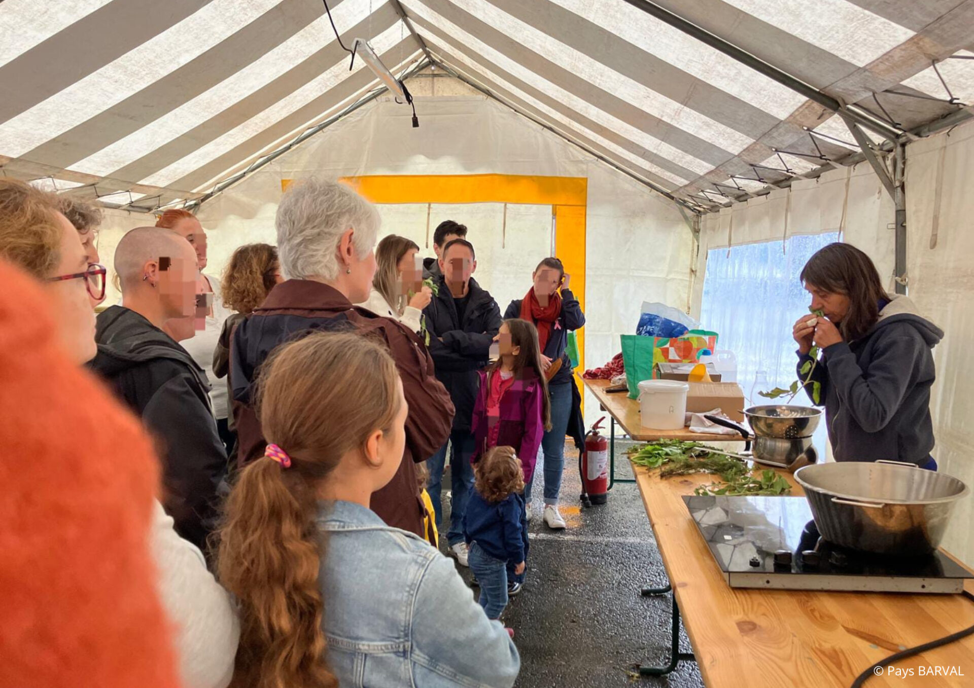 un groupe de personne devant une table en bois ou une personne présente un atelier