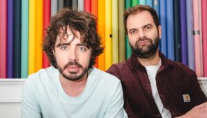 deux hommes barbu devant un fond multicolor