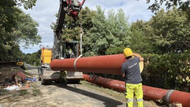 Un touyau rouge soulever par une grue