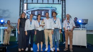 6 personnes debout qui prennent la pose en tenant un trophée dans la main