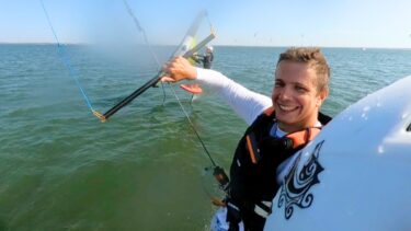 Un jeune homme blond à la barre d'un kitesurf