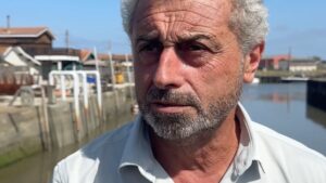 un homme devant un port et des cabanes en bois