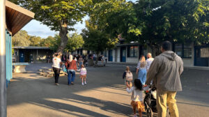 Rentrée scolaire à l'école élémentaire Lafon à Cazaux. On voit des enfants avec leurs parents dans la cour de récréation.