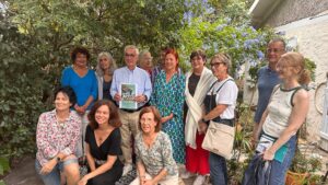 Les artistes du Parcours Ateliers posent pour une photo dans un jardin.