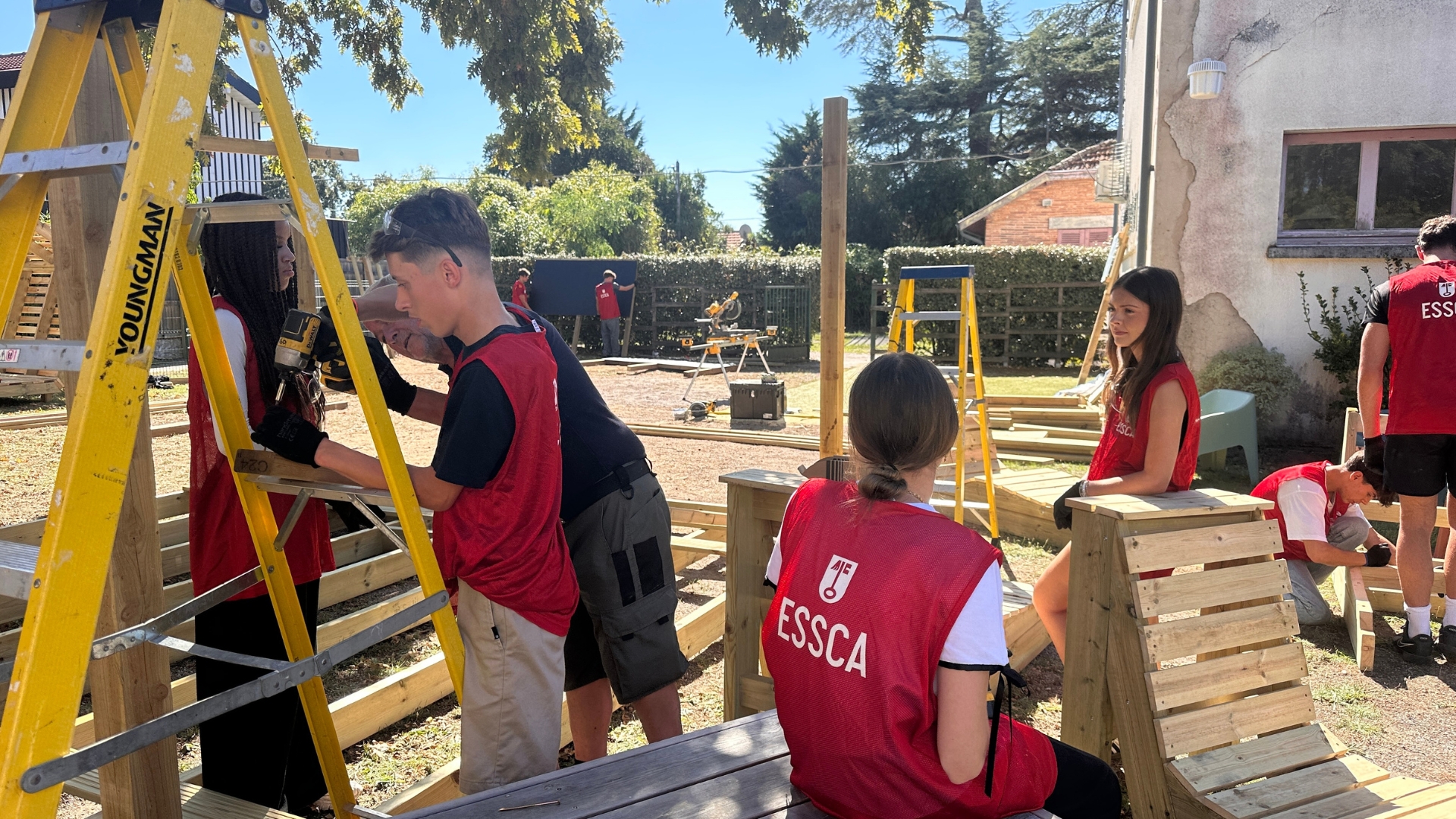 Plusieurs jeunes travaillent autour d'une construction en bois à Taussat, à Lanton.