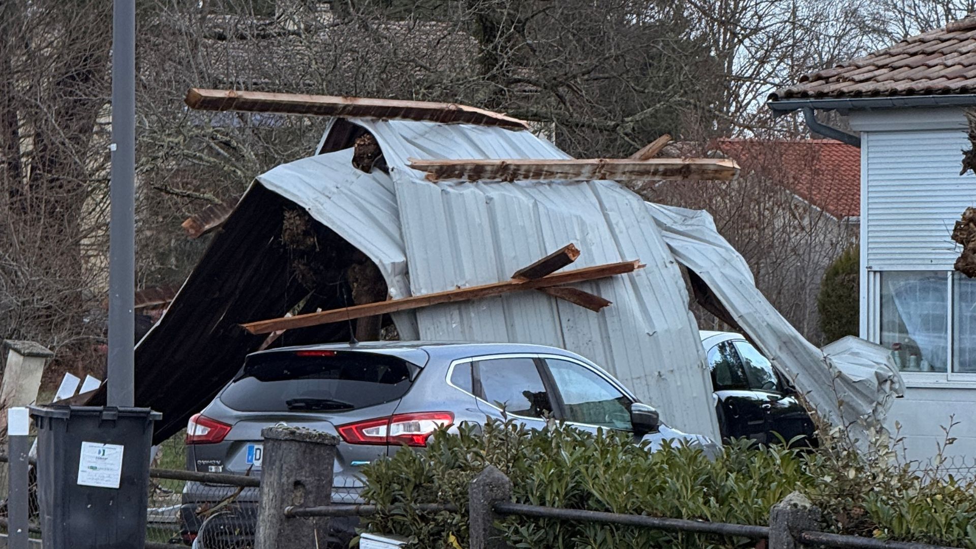 amas de taules et de bois tombé sur une voiure