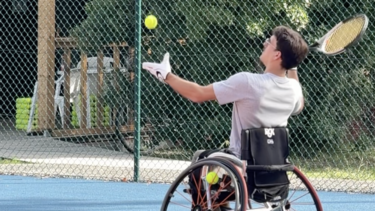 Un homme sur un fauteuil roulant joue au tennis
