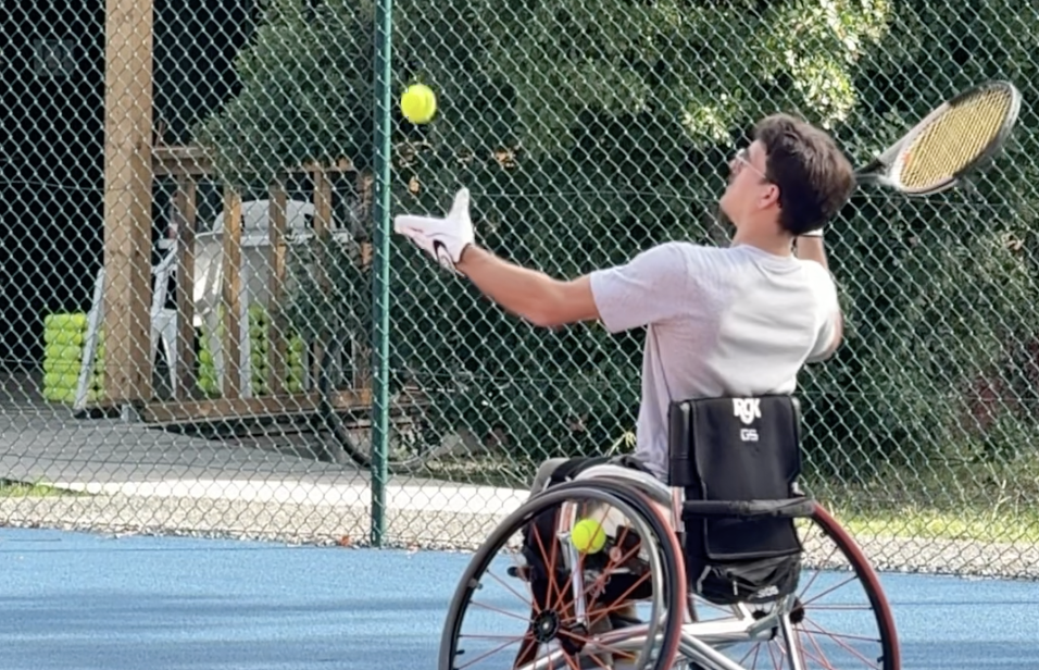 Un homme sur un fauteuil roulant joue au tennis