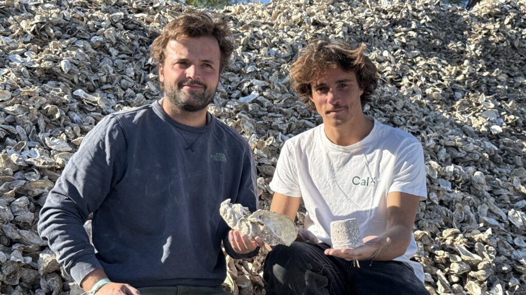 Deux jeunes hommes assis sur un tas de coquilles d'huîtres