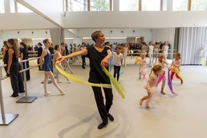 un cours de danse avec des enfants dans une salle blanche