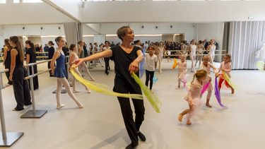 un cours de danse avec des enfants dans une salle blanche