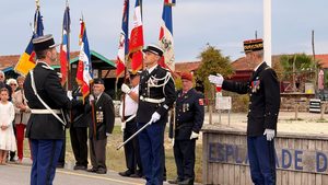 commandant de gendarmerie lors de la cérémonie de prise de commandement sur le port de Larros à Gujan avec des portes drapeaux en arrière plan