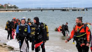 plongeurs en tenue au bord de la plage d'arcachon avec la jetée thiers en arrière plan