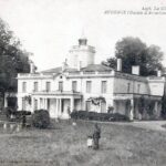 carte postale ancienne en noir et blanc d'un bâtiment en pierre, derrière il y a des arbre