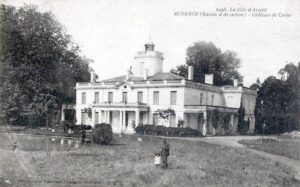 carte postale ancienne en noir et blanc d'un bâtiment en pierre, derrière il y a des arbre