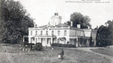 carte postale ancienne en noir et blanc d'un bâtiment en pierre, derrière il y a des arbre
