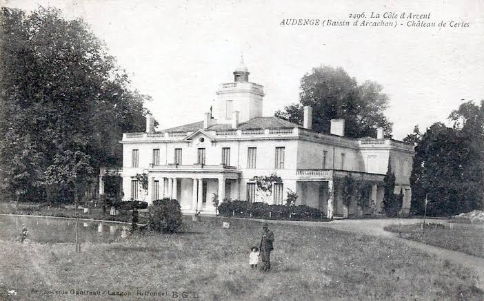 carte postale ancienne en noir et blanc d'un bâtiment en pierre, derrière il y a des arbre